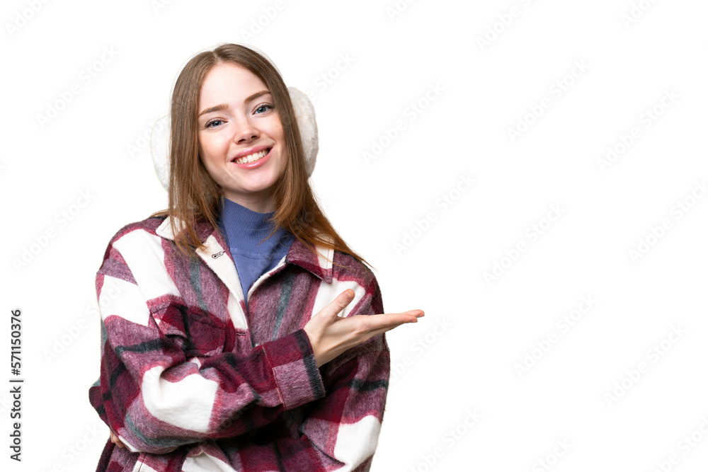 Young pretty woman wearing winter muffs over isolated chroma key background presenting an idea while looking smiling towards Young pretty woman wearing winter muffs over isolated chroma key background presenting an idea while looking smiling towards