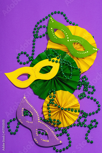 Festive Mardi Gras masquerade purple background. Fat Tuesday carnival, masks, beads, traditional decor