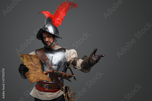Studio shot of isolated on gray background conquistador with map. photo