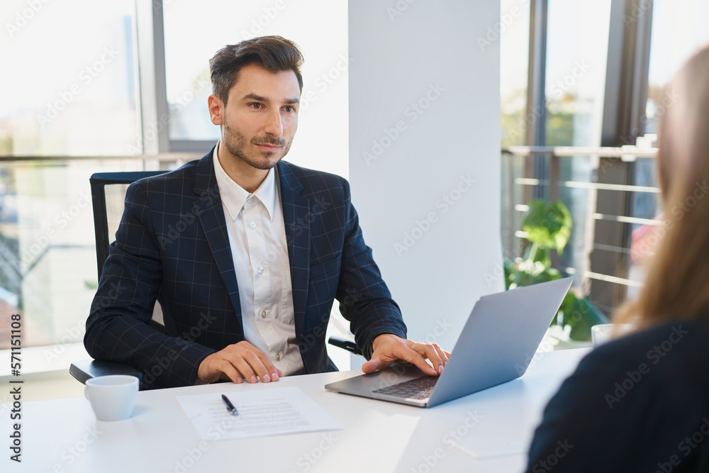 Recruiter with laptop looking at candidate in interview Recruiter with laptop looking at candidate in interview