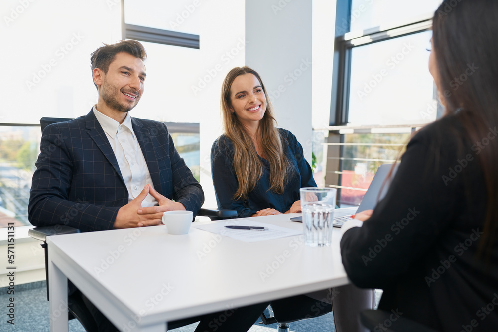 © Westend61 - Smiling recruiters taking interview of candidate at desk in office © Westend61 - Smiling recruiters taking interview of candidate at desk in office