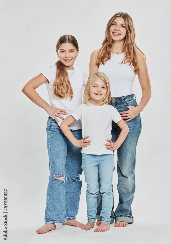 Happy sisters wearing casual clothing against white background
