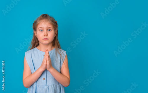фотографія Cute little girl pleading for something with hands clasped together may I please