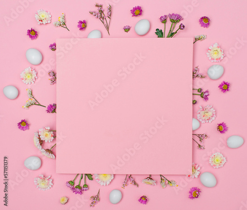 Easter candy eggs and flowers around pink paper copy space. © Polina Ponomareva