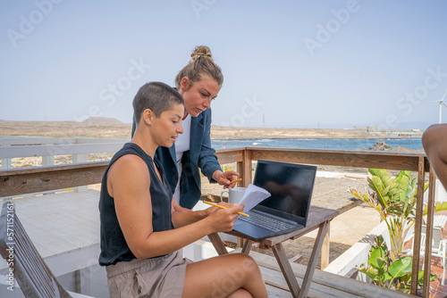 Wallpaper Mural Businesswoman assisting colleague holding book on balcony Torontodigital.ca