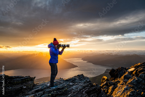 figure with camera above Queenstown and Lake, Remarkables New Zeala