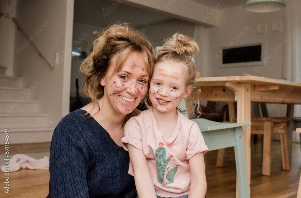 portrait of mother and daughter with make up on their faces portrait of mother and daughter with make up on their faces