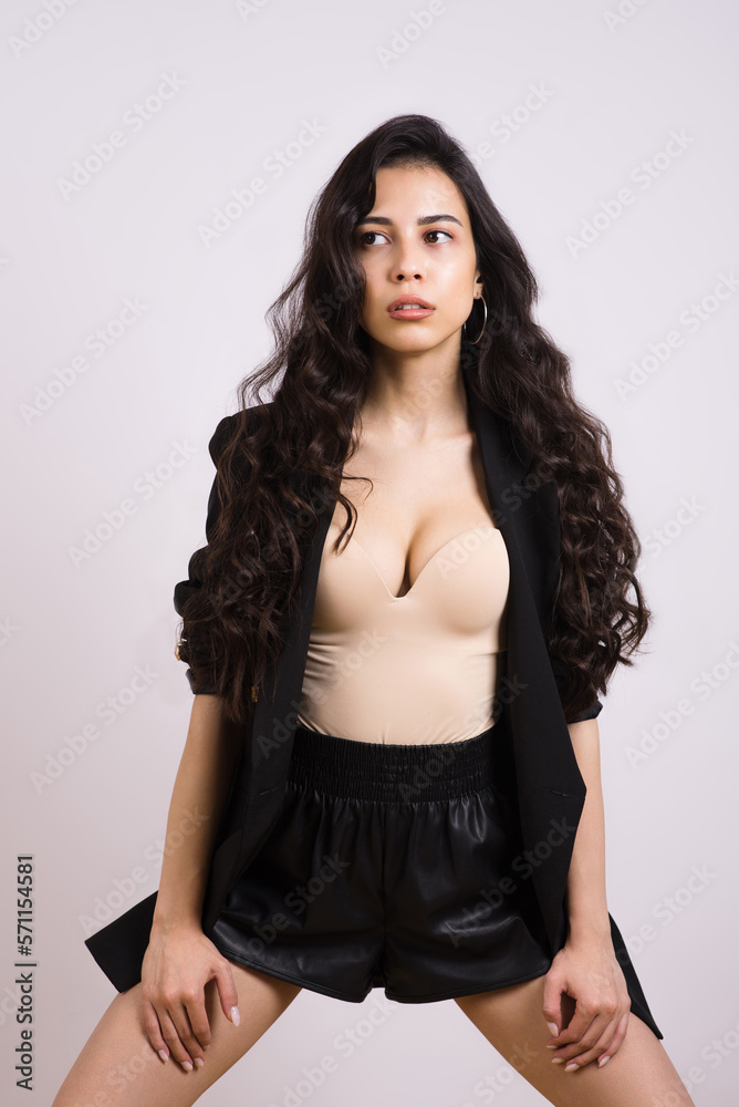 Portrait of a young stylish brunette girl with wavy hair on a white studio background. Portrait of a young stylish brunette girl with wavy hair on a white studio background.