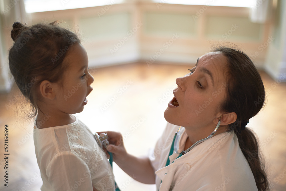 General Practitioner using a stethoscope during check-up a young girl General Practitioner using a stethoscope during check-up a young girl