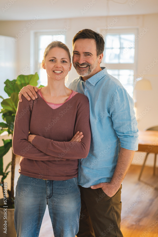 Happy man with hand in pocket standing by wife at home Happy man with hand in pocket standing by wife at home