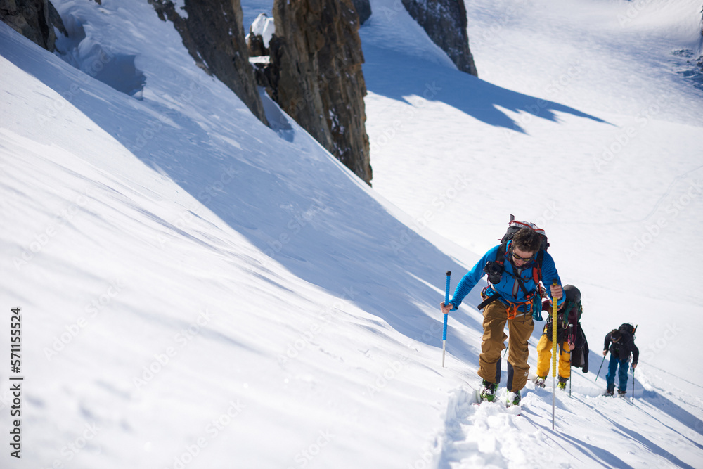 Group of 3 people ski touring up hill Group of 3 people ski touring up hill