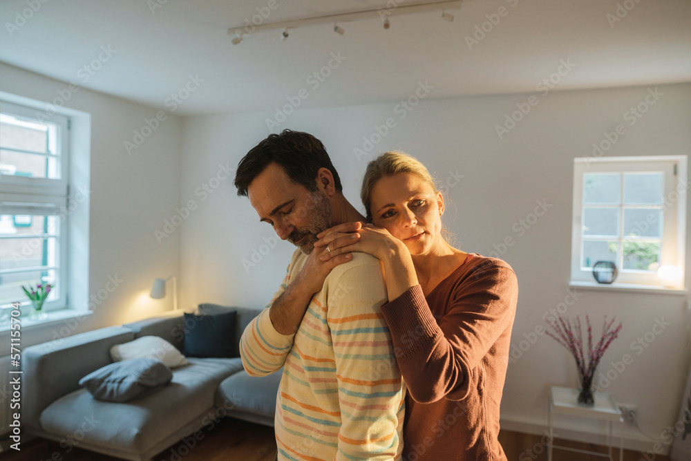 Sad mature couple standing in living room at home Sad mature couple standing in living room at home