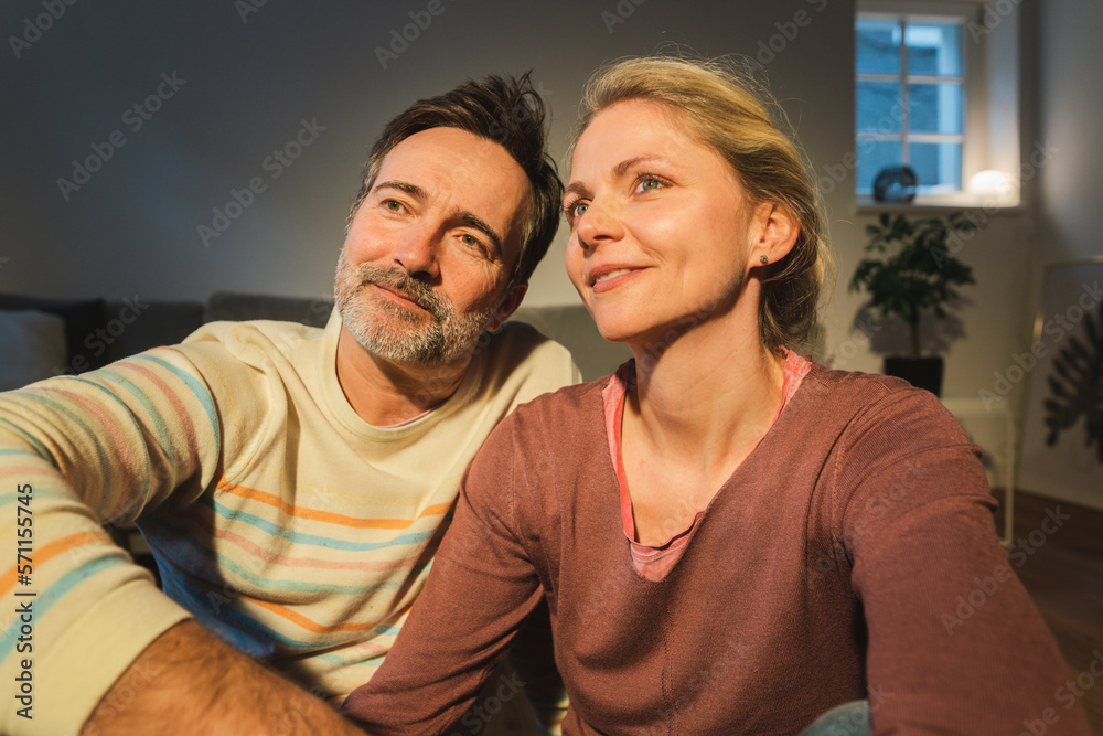 Contemplative mature couple sitting at home Contemplative mature couple sitting at home