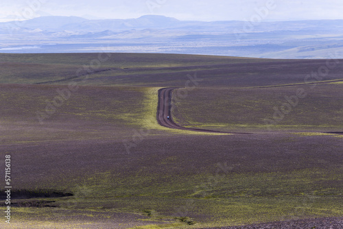 Woman standing in the middle of nowhere on dirt road in highlands photo