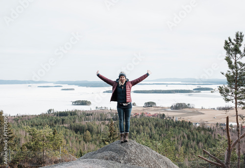 woman jumping for joy as she reaches the top of a hill climbing photo