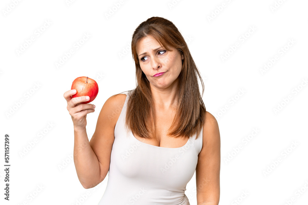 Middle age woman with an apple over isolated background with sad expression Middle age woman with an apple over isolated background with sad expression
