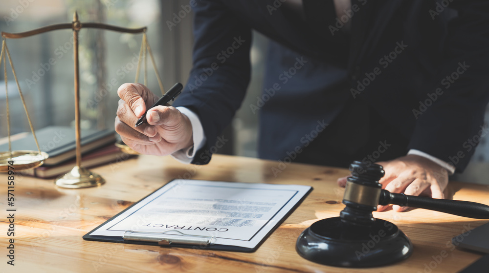 Young Asian lawyer or legal advisor reading clarification on business agreement with the signing of the investment contract according to the laws and regulations in the office. Young Asian lawyer or legal advisor reading clarification on business agreement with the signing of the investment contract according to the laws and regulations in the office.