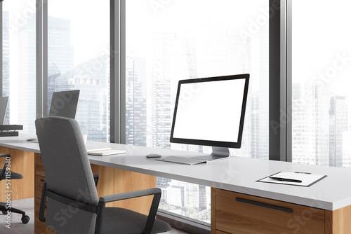Business interior with pc desktop on table with mockup display, panoramic window © ImageFlow
