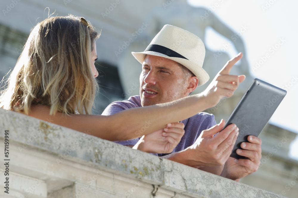 fashion couple outdoors using a tablet