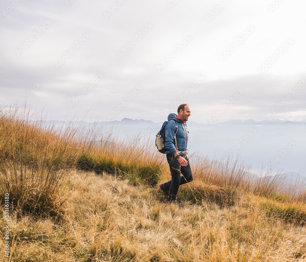 Smiling mature man walking on mountain Smiling mature man walking on mountain
