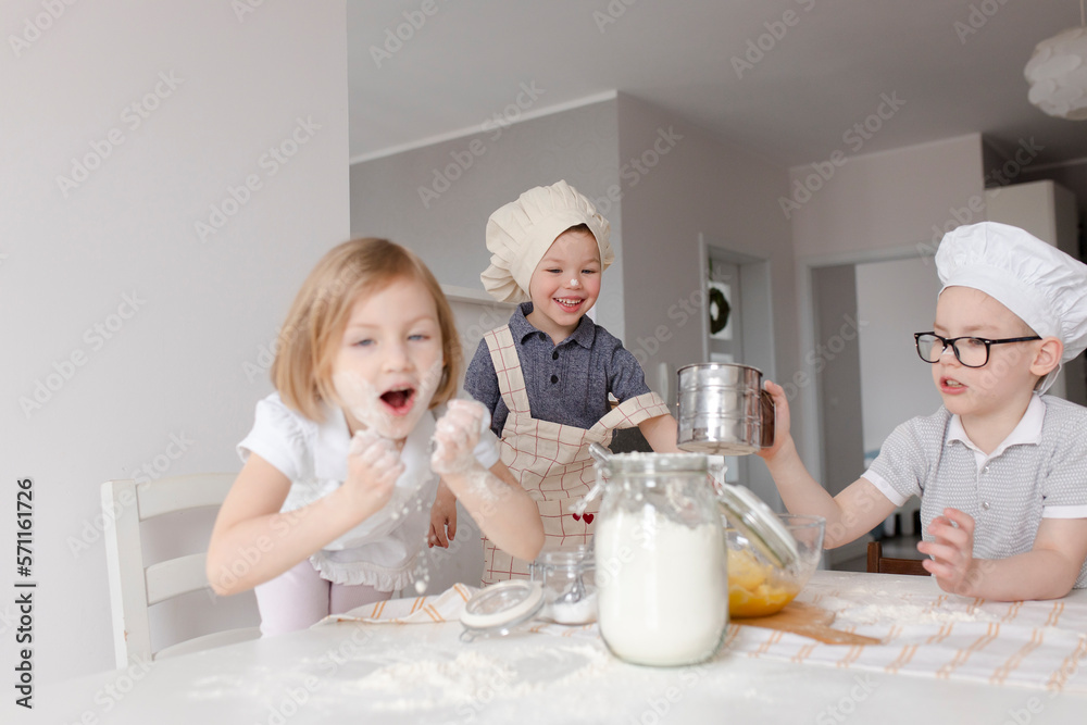 Children having fun preparing dough with flour at home Children having fun preparing dough with flour at home