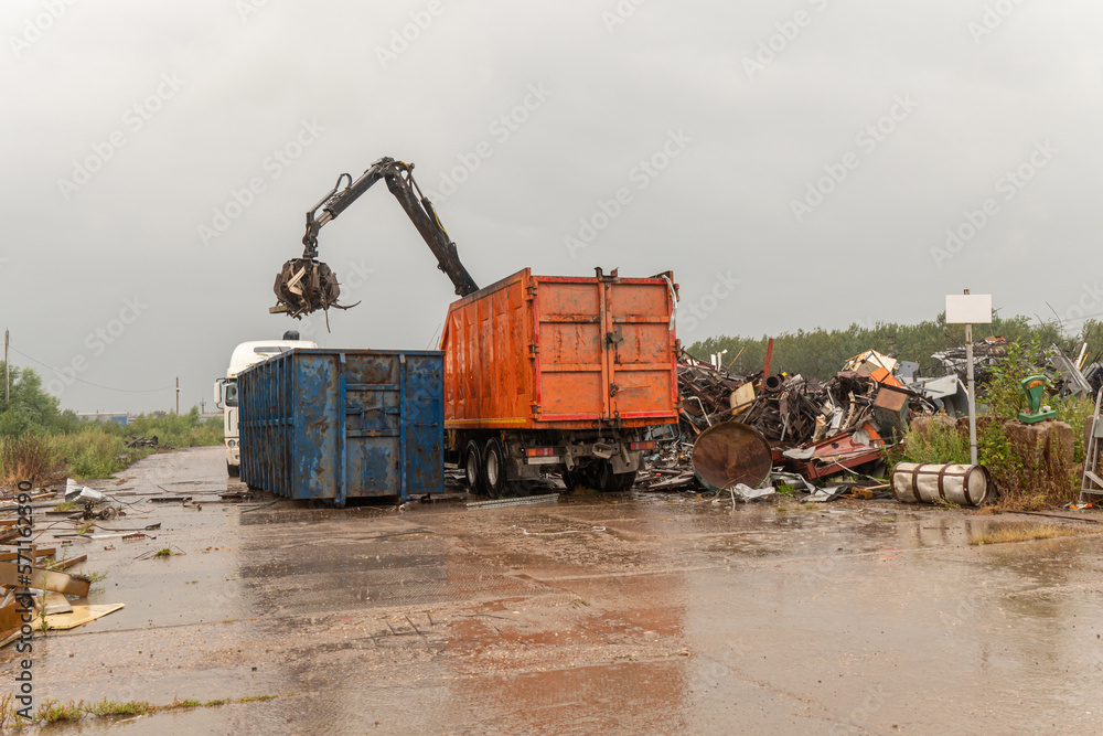 Loading of scrap metal by hydraulic crane, for recycling.