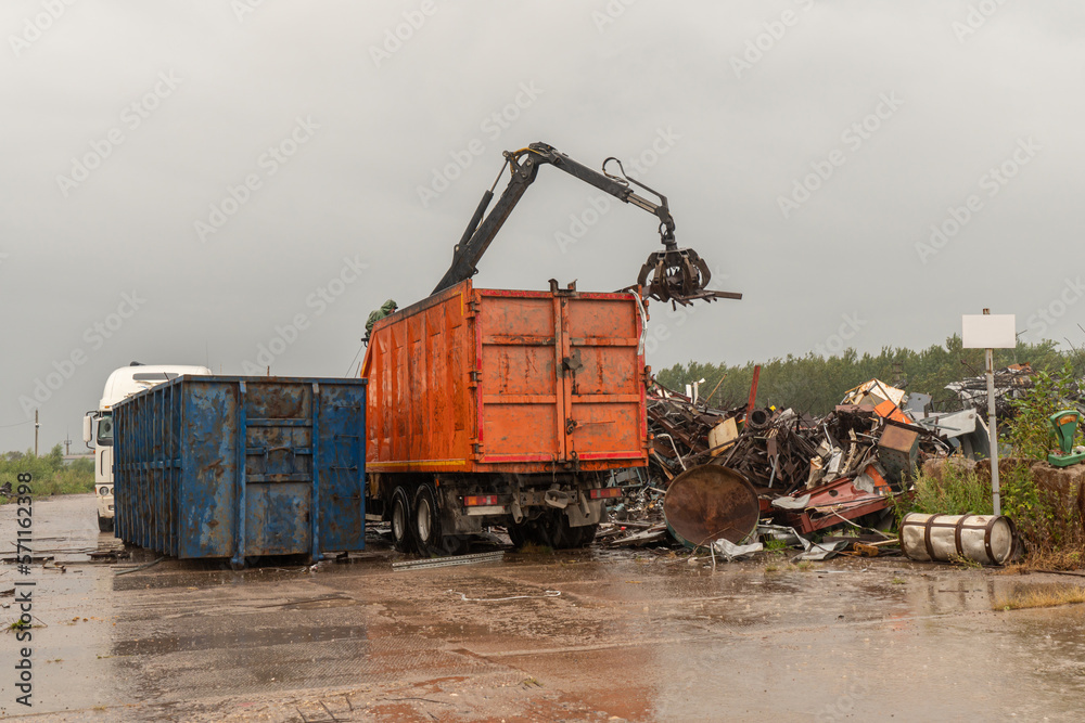 Loading of scrap metal by hydraulic crane, for recycling.