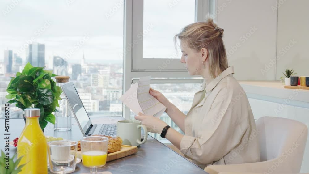 woman looking news on tablet pc during breakfast time. Addiction to gadgets.Breakfast before work in the kitchen. woman looking news on tablet pc during breakfast time. Addiction to gadgets.Breakfast before work in the kitchen.