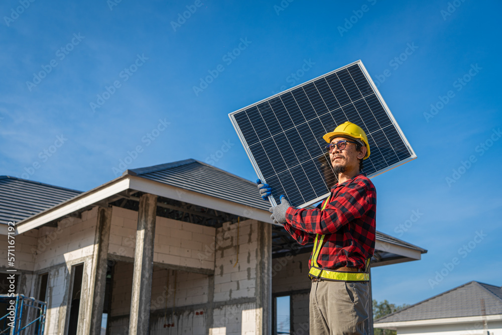 Engineers in helmets installing solar panel system outdoors. technician use a the Electric drill installing the solar panels at roof top of home and home office. 