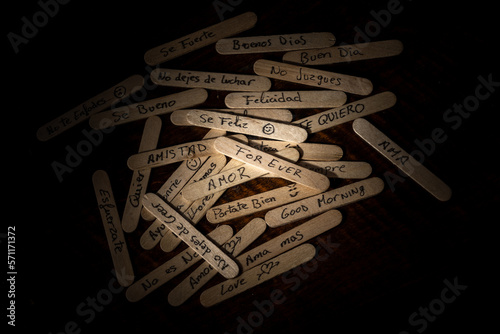 palitos de polo de madera con mensajes escritos a mano con boligrafo, condepto mensajes de la sociedad, tristeza, malos tratos, alegria, enfado, amor