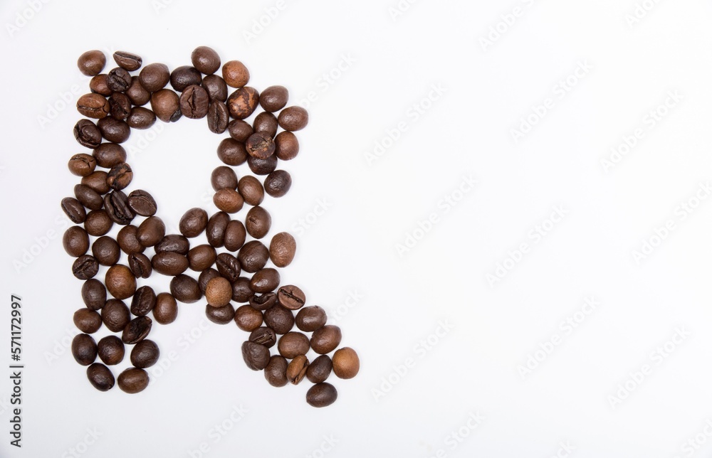 R is a capital letter of the English alphabet made up of natural roasted coffee beans that lie on a white background. R is a capital letter of the English alphabet made up of natural roasted coffee beans that lie on a white background.