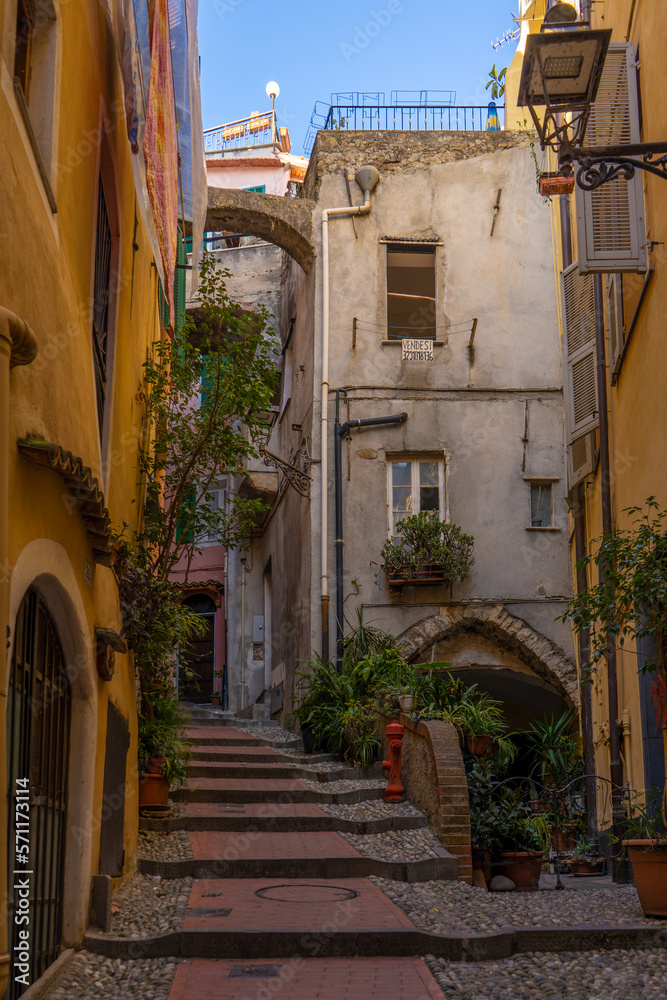 Centro storico di Sanremo, in provincia di Imperia. Piccola strada acciottolata ed edifici residenziali colorati e vista sul porto. Liguria, Italia.