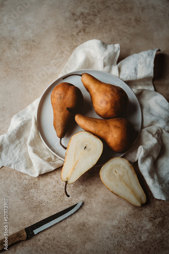 Overhead of pears on a plate against beige background. photo