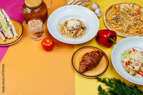 Italian pasta, pizza and caesar salad on bright backgrounds. moc photo