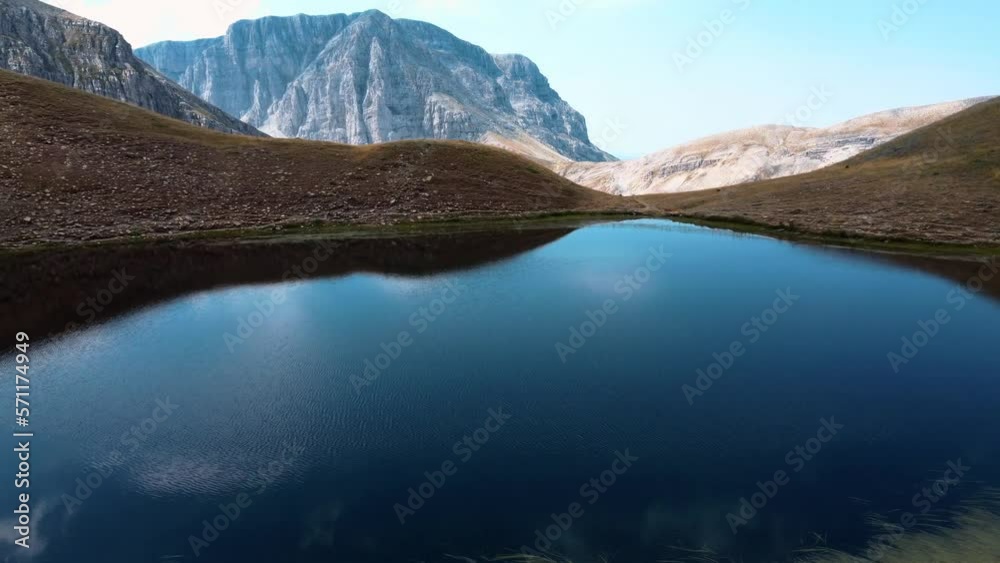 Drone video of alpine Dragon Lake, located in Mount Timfy in Epirus-Greece. A mesmerizing body of water surrounded by majestic peaks with unspoiled beauty and serene atmosphere | 4K