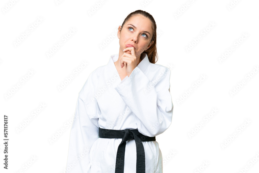 Young blonde woman doing karate over isolated chroma key background having doubts Young blonde woman doing karate over isolated chroma key background having doubts