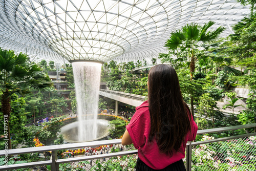 Young female tourist looking at the indoor waterfall in Changi Airport, Singapore photo