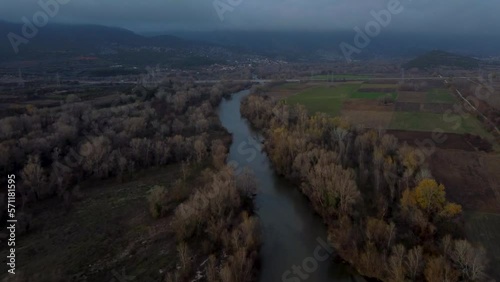 Aerial establishing shot over river and forest in winter. Nestos, Greece. photo