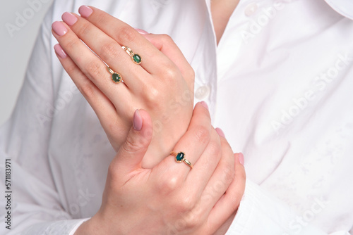 Woman Jewelery concept. Woman hands close up wearing rings  earrings and necklace modern accessories elegant life style.