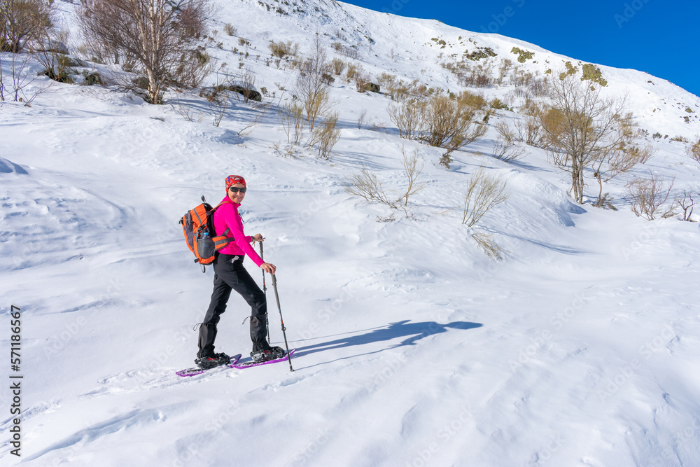 smiling woman on snowy mountain with snowshoes, backpack and poles smiling woman on snowy mountain with snowshoes, backpack and poles