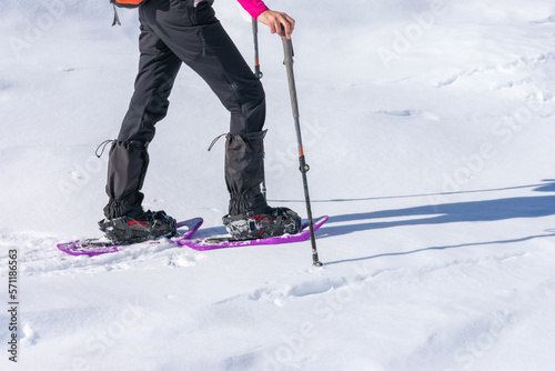 mountaineer with snowshoes and hiking poles in the snow