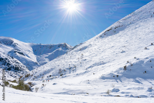 mountaineers walking on snowy mountain on sunny day © photointruder