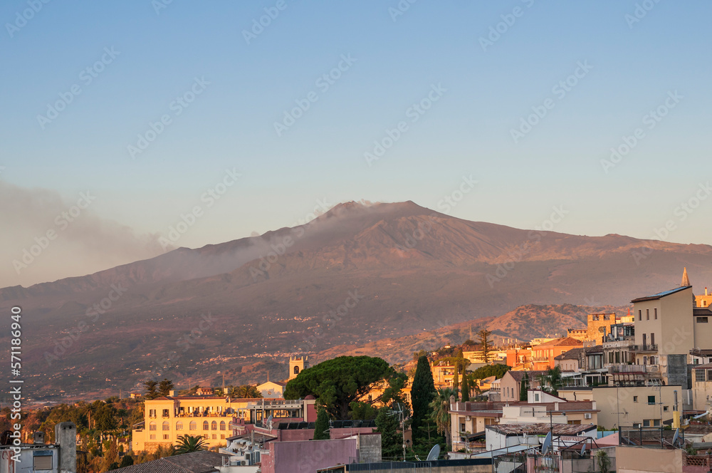 View of Mount Etna from the city of Taormina / View of Mount Etna volcano in the morning, from the city of Taormina on the island of Sicily, Italy.