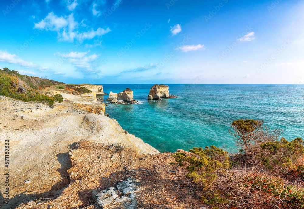 Picturesque seascape with white rocky cliffs, sea bay, islets and faraglioni near by beach Spiaggia della Punticeddha,