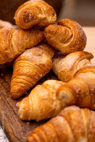 Croissant. Bakery. Vertical photo of croissant stacked on wooden board.