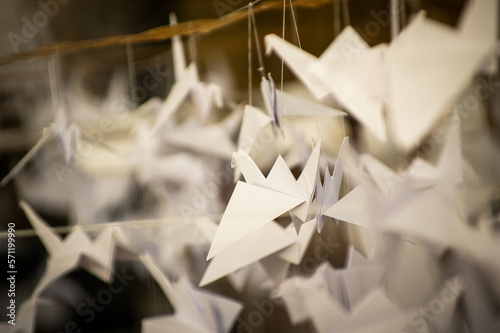 Japanese folded Origami cranes hanging on with strings. Hundreds handmade paper birds isolated with copy space. 1000 thousand crane sculpture topic. Symbol of peace, faith, health, wishes, hope
