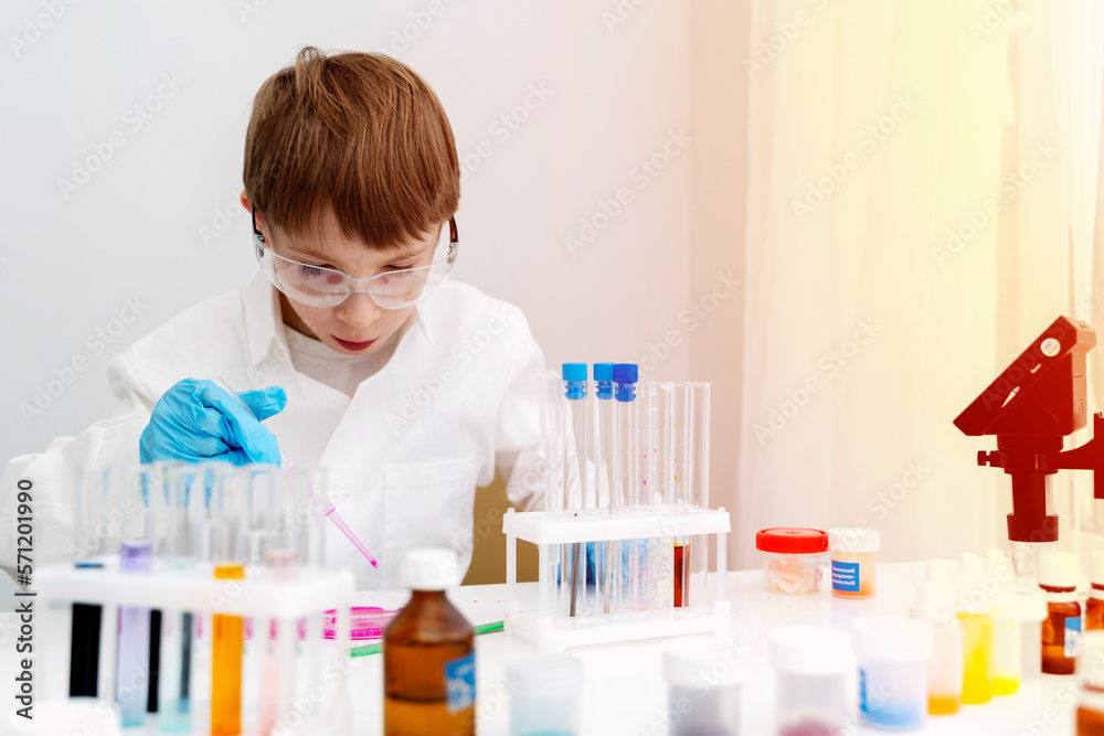 the boy conducts experiments in a chemical laboratory
