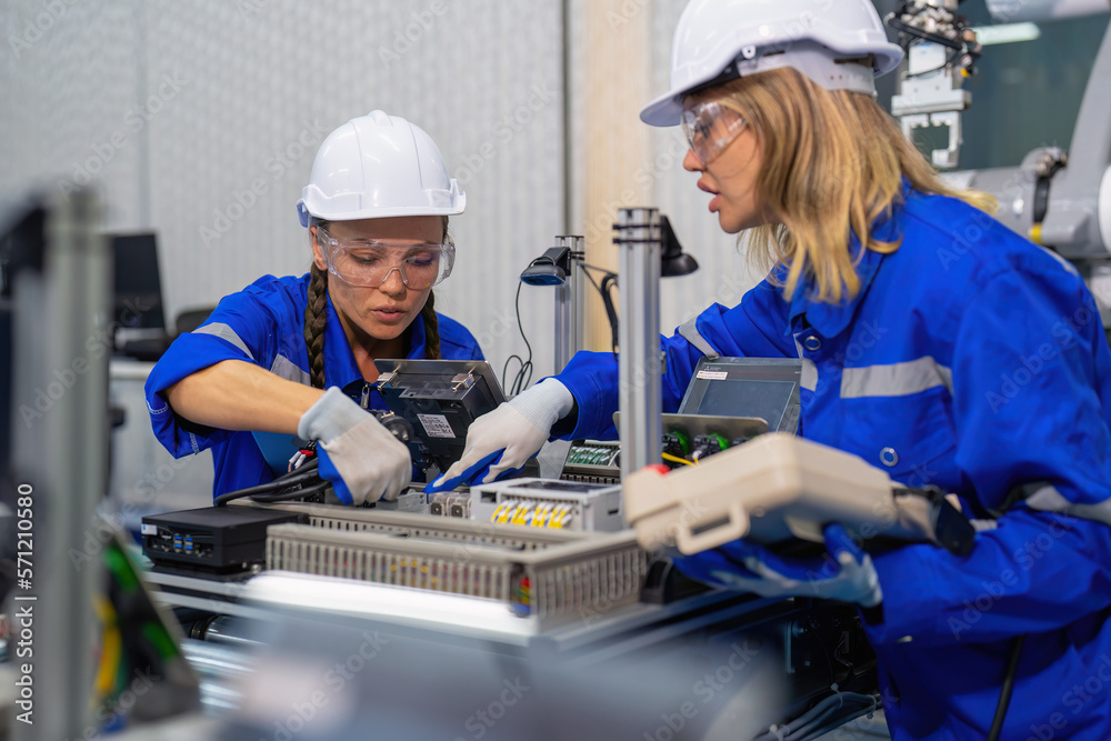 Female Electronics Factory Workers use tablet pc quality checking Circuit Boards after assembly