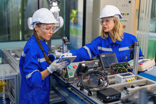 Female Electronics Factory Workers use tablet pc quality checking Circuit Boards after assembly