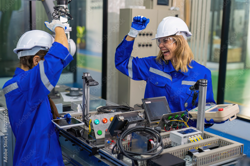 Fototapeta premium Female Electronics Factory Workers use tablet pc quality checking Circuit Boards after assembly